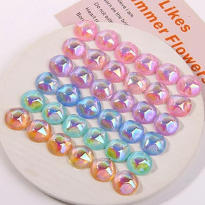 Holographic half-round resin beads in pastel colors on a white ceramic tray for DIY jewelry