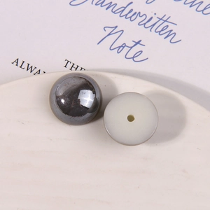 Detailed macro view of gunmetal mirror finish and translucent ivory resin beads for DIY crafts