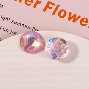 Macro shot of iridescent round cabochon charms with shimmering starry glitter effects