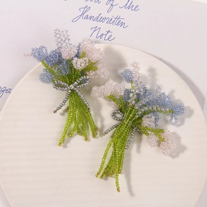 Detailed view of handmade beaded lavender tulip bouquets with silver bow on ceramic tray