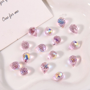 Faceted Aurora AB pink glass teardrop beads for DIY jewelry making on a white tray