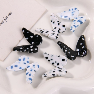 Close-up of acetic acid butterfly charms with polka dots for DIY jewelry making