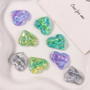 Makroansicht bunter Herzanhänger aus Harz mit Glitzer-Wasserwellenstruktur für DIY-Schmuck