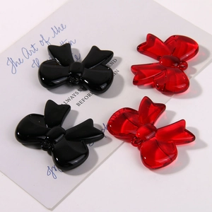 Detail of glossy resin 3D bow pendants in black and translucent red for DIY jewelry