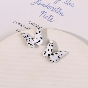 Detail view of butterfly resin charms with dalmatian dots for DIY jewelry making