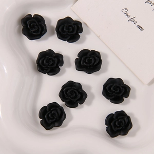 Detalle de ocho rosas de resina negra mate en bandeja blanca para artesanías DIY