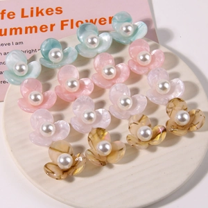 Flat lay of 12pcs floral acetate hair accessories with pearls on a ceramic plate