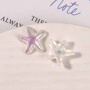 Macro shot of iridescent resin starfish charms with glitter finish on a white ceramic tray