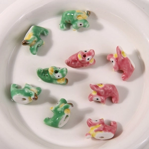Macro-opname van handbeschilderde keramische monsterkralen in groen en roze op wit dienblad