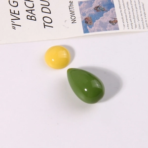Detail van gele ronde en groene traanvormige harskralen voor DIY-sieraden voor oorbellen