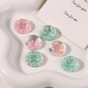 Detail view of handmade resin flower charms with pink and green gypsophila and glitter