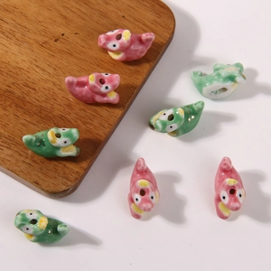 Macro-opname van handbeschilderde keramische dinosaurus kralen voor DIY sieraden maken