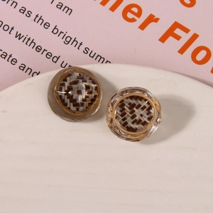 Macro shot of retro resin shoe charms with woven texture and gold metal frame on tray
