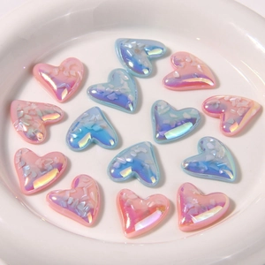 Macro shot of colorful gradient resin heart charms with iridescent crushed shell inlay