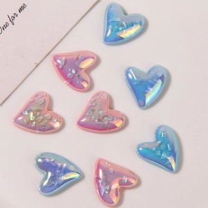Macro shot of iridescent resin heart charms with embedded shell fragments for DIY crafts