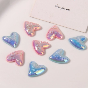 Close-up of iridescent heart-shaped resin charms with colorful crushed shell textures