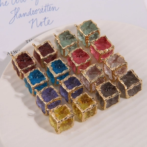Macro detail of colorful cracked resin square pendants with irregular gold metal frames