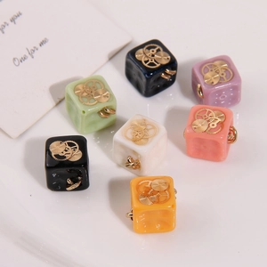 Macro shot of steampunk cube resin pendants with golden gears for DIY jewelry making