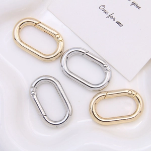 Detailed view of oval alloy spring snap hooks in gold and silver for bags and keychains