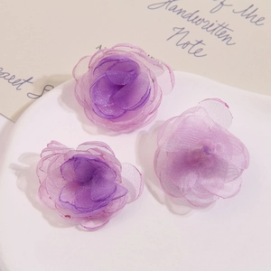 Detailansicht von drei handgefertigten Organza-Blumen mit violettem Farbverlauf in einer Schale