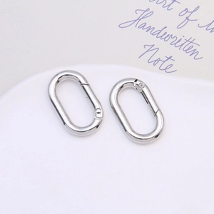 Close-up of dual silver oval spring snap hooks with polished finish for keychains