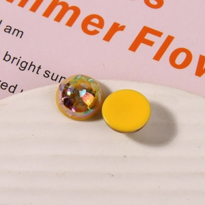 Dettaglio macro di ciondoli tondi in resina con glitter aurora e retro giallo per DIY