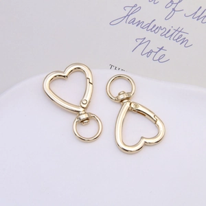 Close-up of heart-shaped gold alloy spring rings with 360-degree swivel lobster clasps