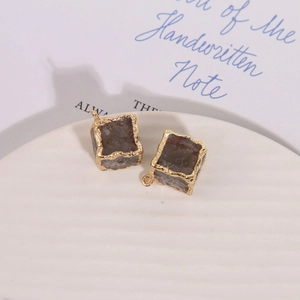 Detailed view of square faux stone pendants with textured gold edges for jewelry making