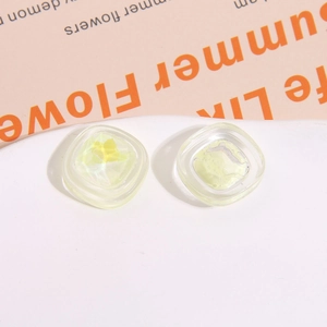 Dettaglio macro di ciondoli quadrati in resina gialla con trama gelatina per fermagli DIY