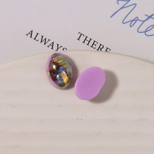Dettaglio macro del cabochon ovale in resina con scaglie di conchiglia per artigianato DIY