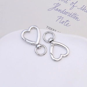 Macro shot of silver zinc alloy heart-shaped spring clasps with 360-degree swivel ring