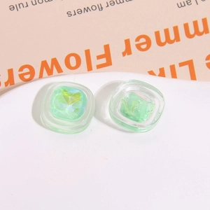 Dettaglio di ciondoli quadrati in resina verde con effetti laser per accessori per capelli