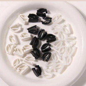 Detailed view of black and white plastic sneaker buckle clips for DIY shoe accessories