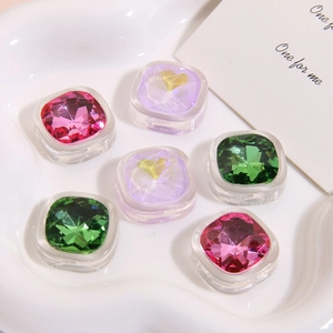 Macro shot of square faceted resin charms with heart motifs for DIY earring jewelry making
