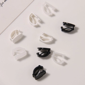 Close-up of black and white plastic shoelace buckle clips for DIY shoe accessory projects