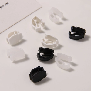 Macro shot of matte plastic shoelace clips and buckles in black white and transparent colors