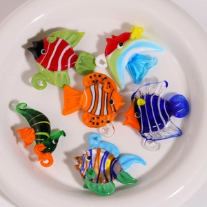 Gros plan de perles en verre coloré en forme de poissons tropicaux pour création de bijoux