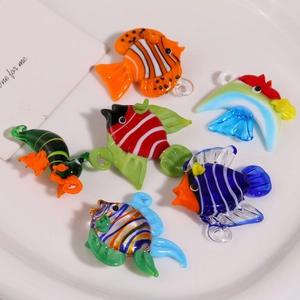 Détail macro de breloques poissons tropicaux en verre coloré pour la création de bijoux