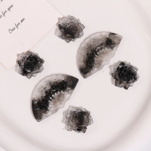 Detailed macro view of retro black floral resin fan charms for DIY jewelry making