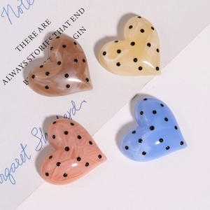 Accessori in resina a cuore con trama marmorizzata e pois neri in quattro colori delicati