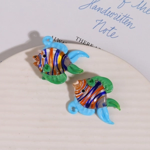 Détail macro de perles en verre soufflé main en forme de poissons tropicaux rayés bleus