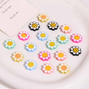 Bunte Acryl-Blumenperlen mit Smiley-Gesichtern für DIY-Schmuck auf weißem Tablett