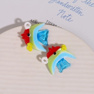Macro de deux breloques poissons en verre coloré faits main pour la création de bijoux