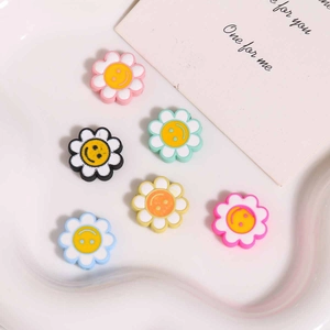 Detail von bunten Smiley-Blumenanhängern in einer weißen Dekoschale für DIY-Bastelarbeiten