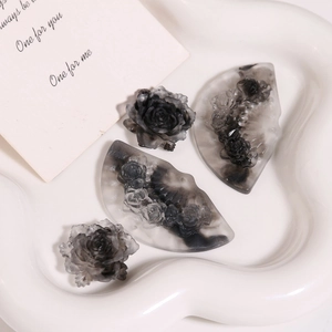 Detailed close-up of smoky ink marble resin rose and fan-shaped DIY jewelry charms