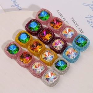 Dettaglio macro di ciondoli quadrati in resina glitterata con cristallo sfaccettato in vari colori