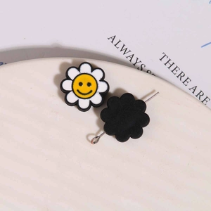 Detail eines bunten Sonnenblumen-Anhängers mit Smiley-Gesicht und weißem Blütenblatt