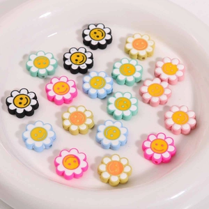 Bunte lächelnde Blumenperlen in Keramikschale für DIY-Schmuck und Bastelarbeiten