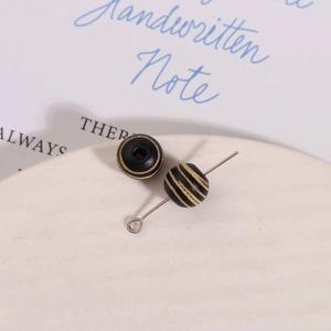 Macro detail of 10mm striped wood beads with a metal T-pin for DIY jewelry making