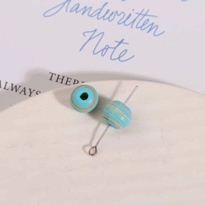 Detail of 10mm light blue striped wooden beads with silver metal pin for DIY jewelry